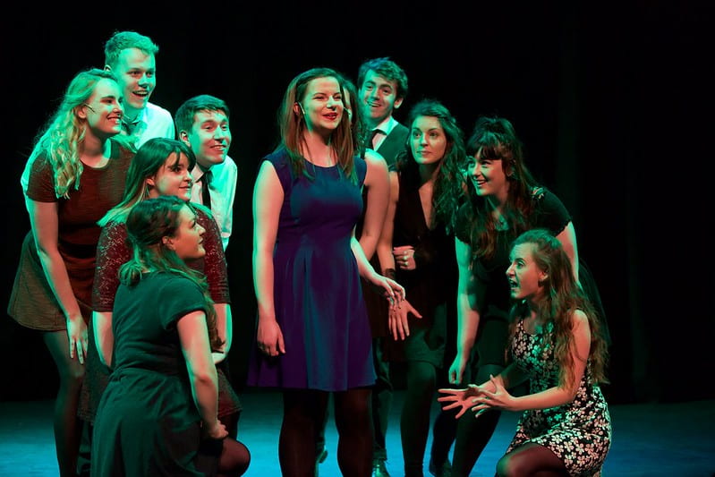 Musical Theatre students singing in a group on stage 